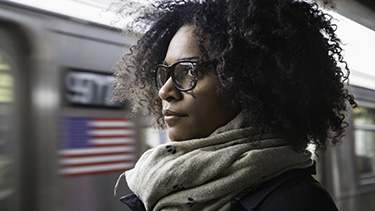 A woman looks into the distance at a subway station.