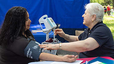 A technician takes a patient's blood pressure.
